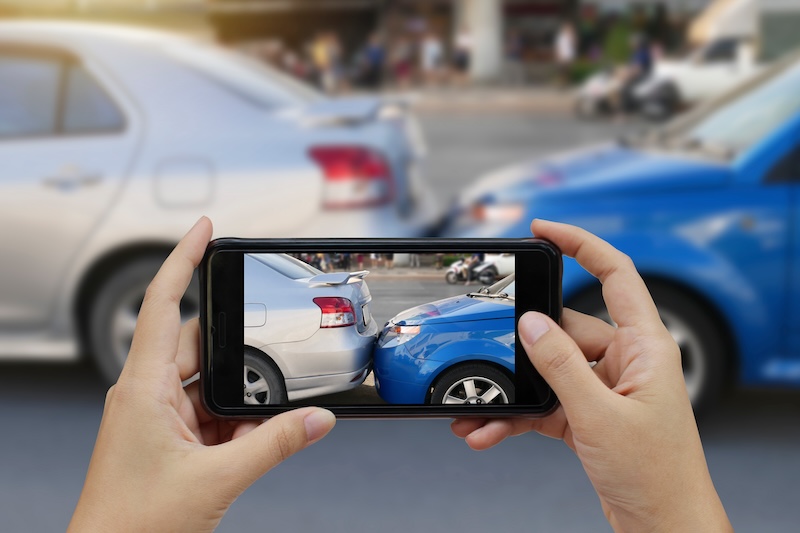 Close up hand holding smartphone and take photo Close up hand holding smartphone and take photo at The scene of a car crash and accident, car accident for car insuranc claim.